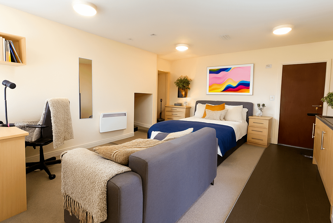 Luxury student studio apartment at Bayt Student Accommodation in Lancaster City Centre, featuring a premium double bed, plush sofa, and modern kitchenette