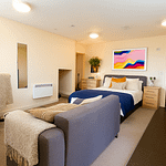Luxury student studio apartment at Bayt Student Accommodation in Lancaster City Centre, featuring a premium double bed, plush sofa, and modern kitchenette