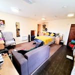 Luxury student studio apartment at Bayt Student Accommodation in Lancaster City Centre, featuring a premium double bed, plush sofa, and modern kitchenette